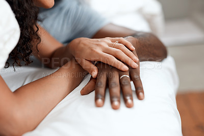 Buy stock photo Closeup of an unrecognizable couple's hands holding each other while they sleep in bed at home in the morning
