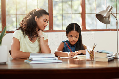 Buy stock photo Cropped shot of an attractive young mother helping her daughter with some homework