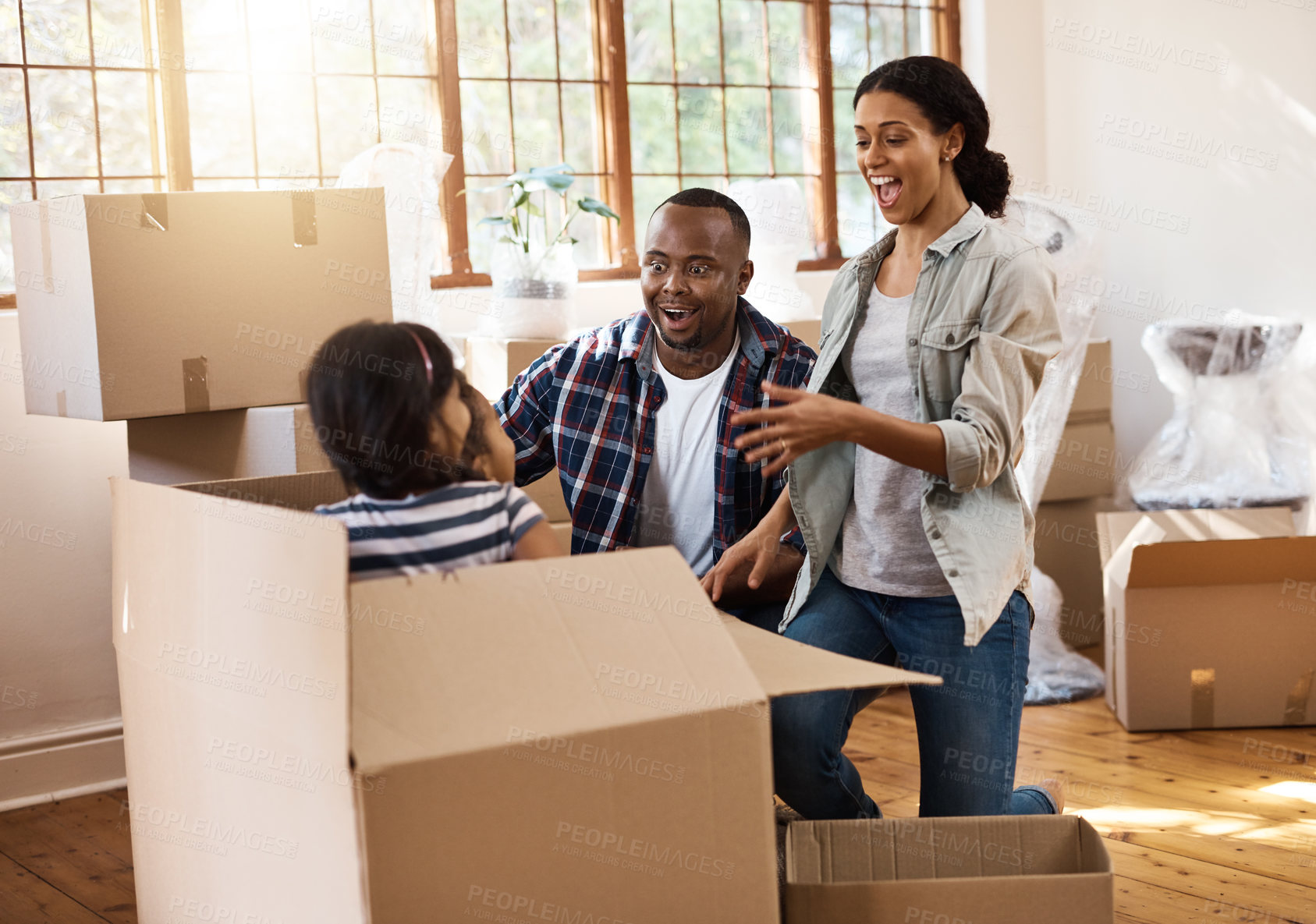 Buy stock photo Parents, kids and happy with boxes for moving in at new house with fun, playing and silly. People, home and excited or smile as interracial family with furniture for apartment with support and love