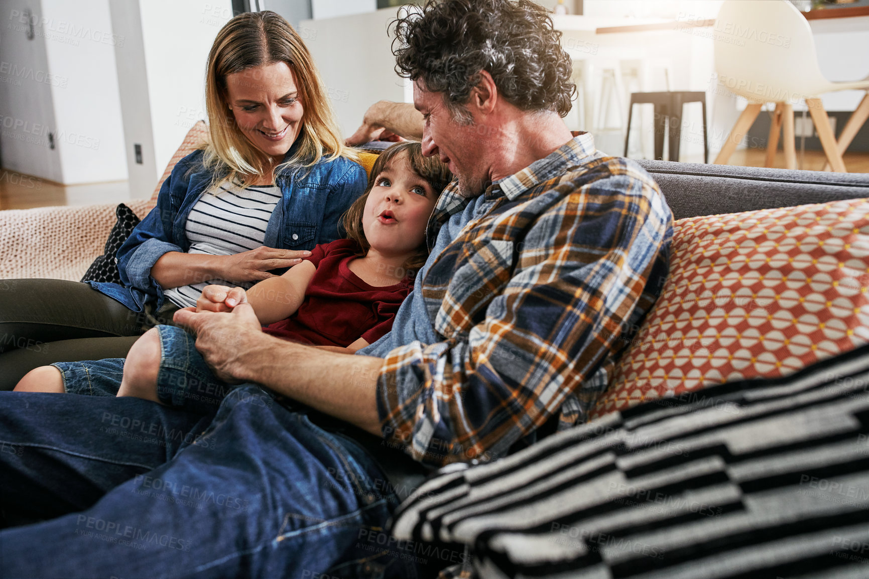 Buy stock photo Mother, Father and kid talking on sofa in living room for love, quality time and relax together at home. Young boy, child and conversation with parents in lounge for support, happy family and care