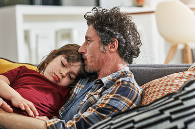 Buy stock photo Cropped shot of an adorable little boy sleeping on his mature father's chest on the sofa at home