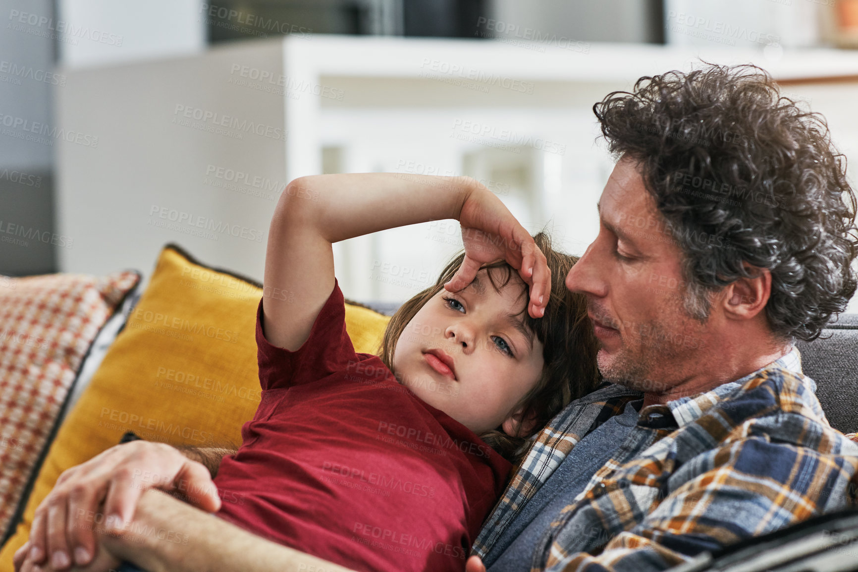 Buy stock photo Cropped shot of a mature father and his young son chilling on the sofa together at home