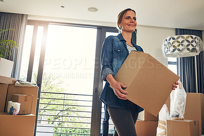 Buy stock photo Shot of a cheerful middle aged woman holding a box while moving into her new home inside during the day