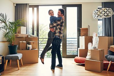 Buy stock photo Portrait of a cheerful middle aged couple holding each other in excitement after moving into their new home inside during the day