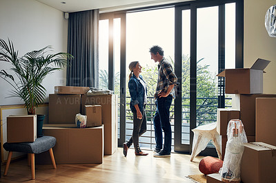 Buy stock photo Shot of a cheerful middle aged couple looking into each other's eyes while being surrounded by boxes on moving day inside at home during the day