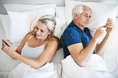 Buy stock photo Couple, phone and ignore in bed in home for chat app, doom scrolling or reading email above. Morning, mature man and woman on mobile in bedroom for internet addiction, disconnect or relax in top view