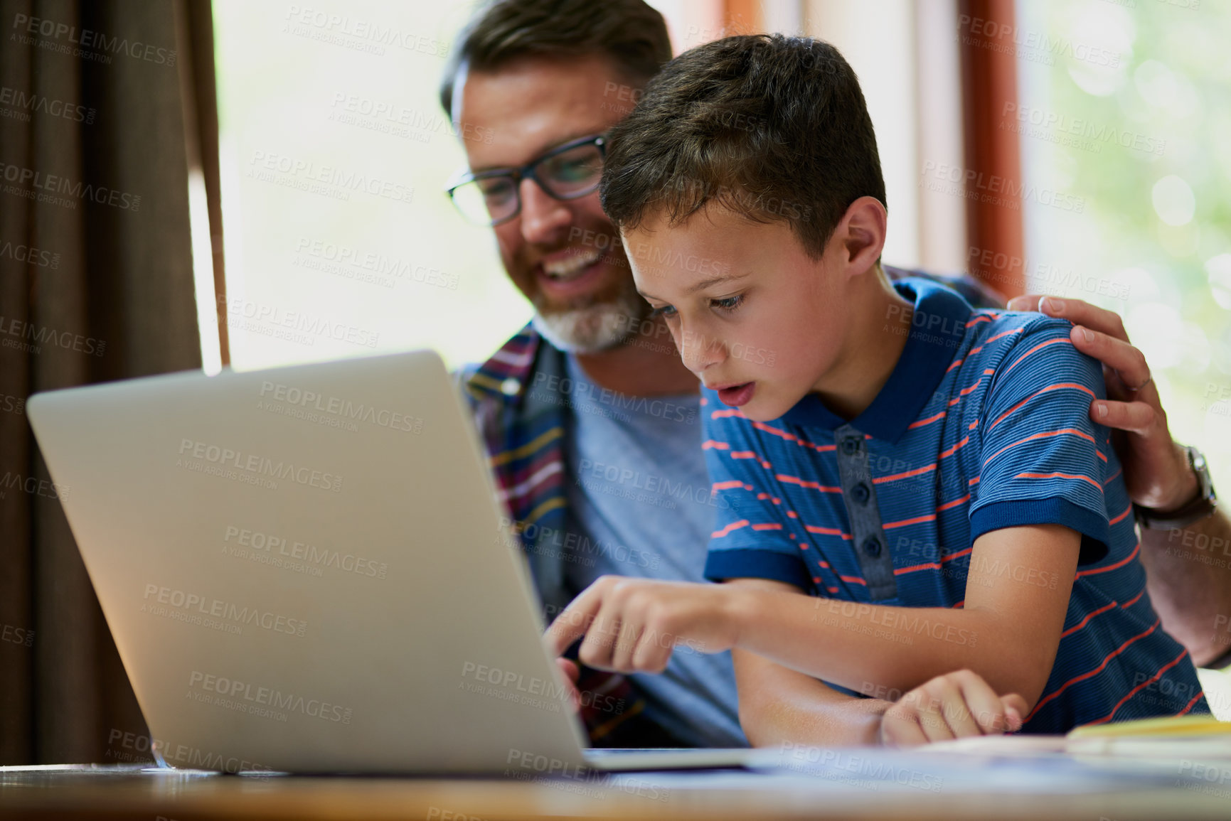 Buy stock photo Cropped shot of a mature father and his adorable son using a laptop together at home