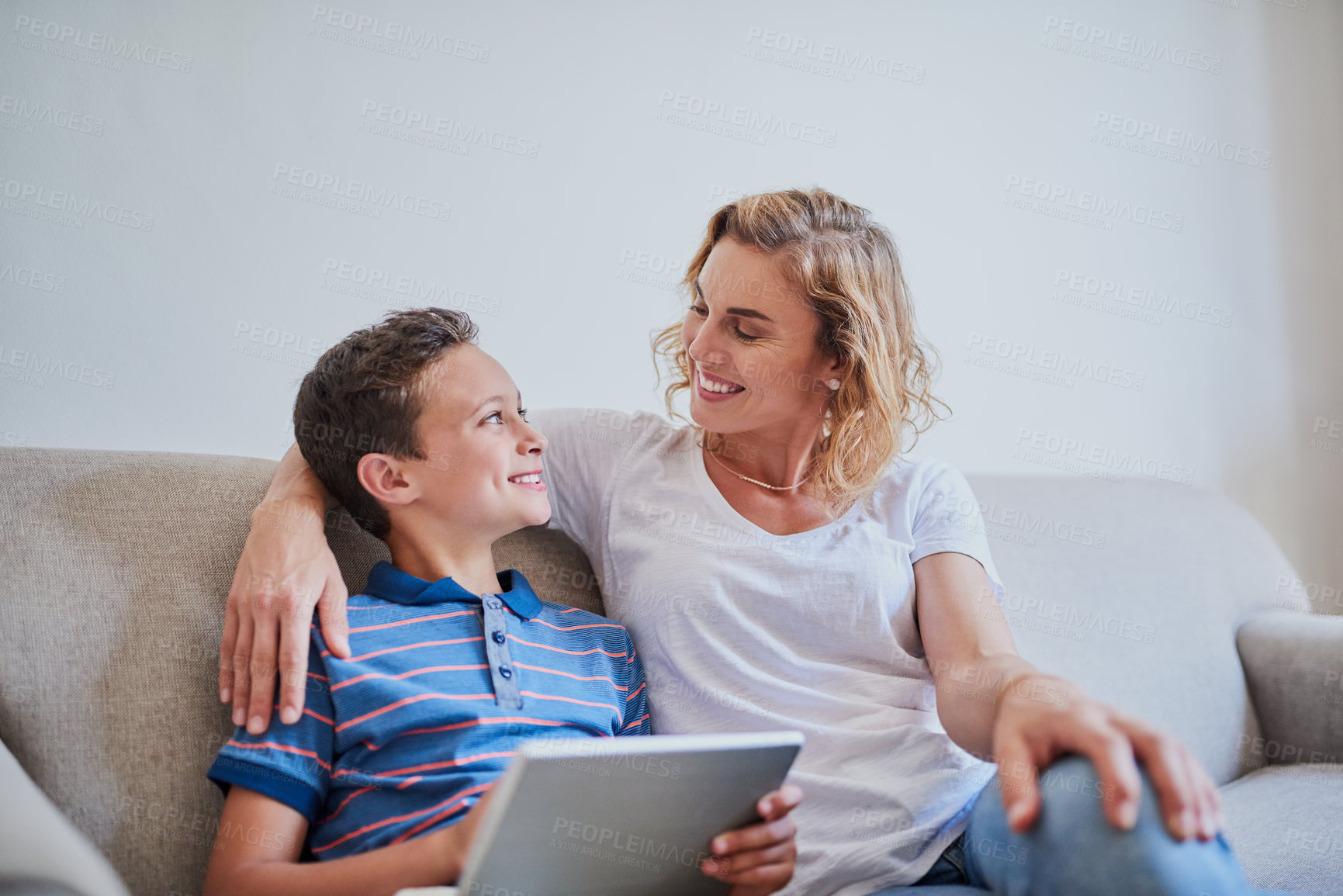 Buy stock photo Happy mother, son and sofa with tablet for entertainment, online games or research at home. Young, mom and child or kid with technology for browsing, scrolling or streaming for cartoon at house