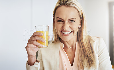 Buy stock photo Portrait of a cheerful middle aged businesswoman enjoying a glass of orange juice in the kitchen during the day