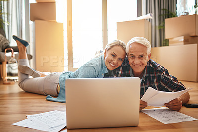 Buy stock photo Portrait of a mature couple using a laptop and going through paperwork together on moving day