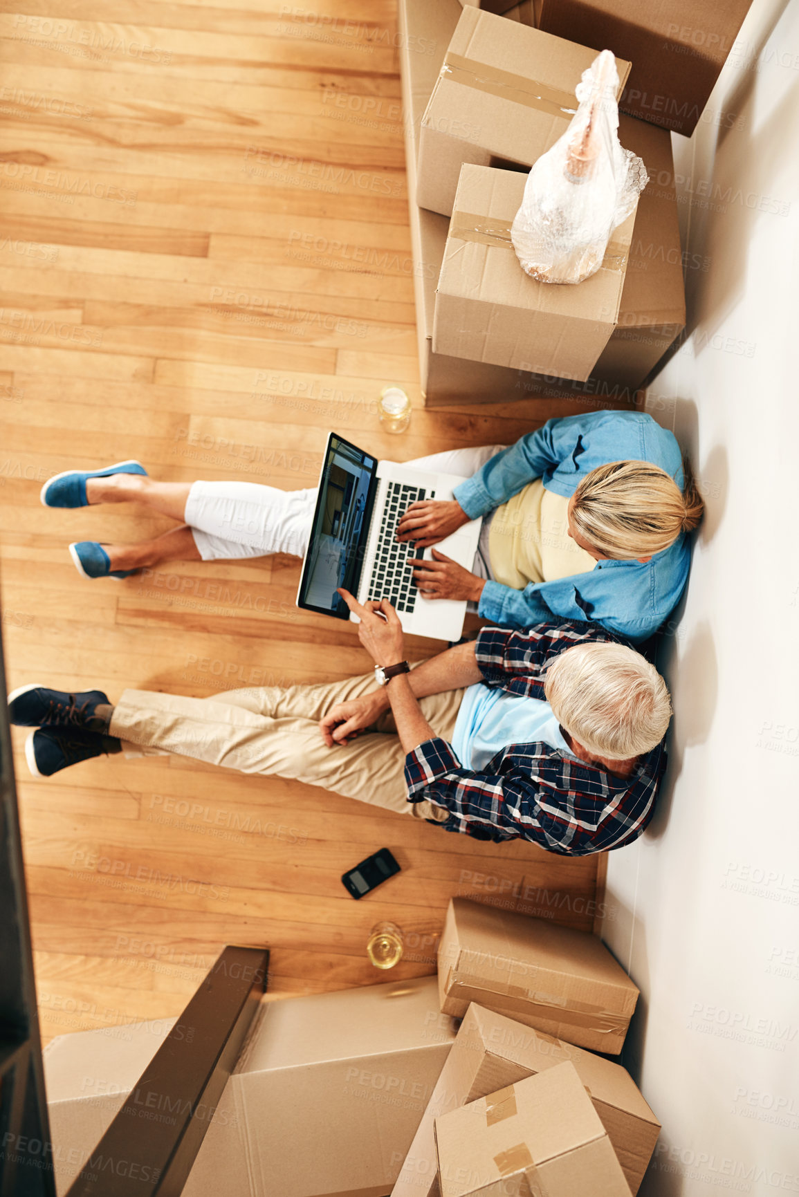 Buy stock photo High angle shot of a mature couple using a laptop together on moving day
