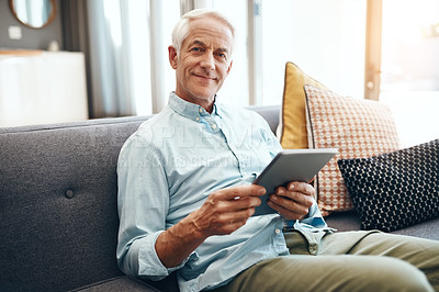 Buy stock photo Cropped shot of a senior man relaxing and using a tablet on the sofa at home