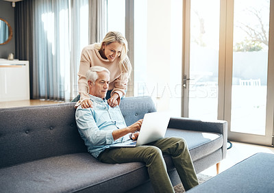 Buy stock photo Shot of mature couple using a laptop on the sofa at home