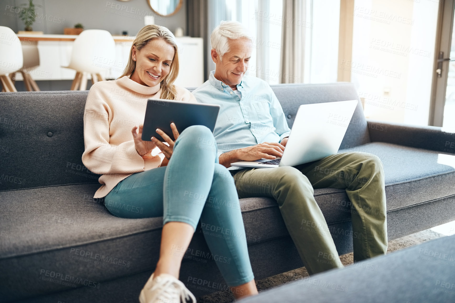 Buy stock photo Cropped shot of mature couple using a laptop on the sofa at home