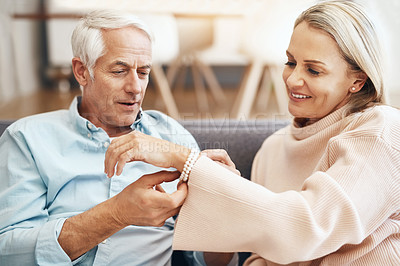 Buy stock photo Cropped shot of mature man giving his wife a gift on the sofa at home