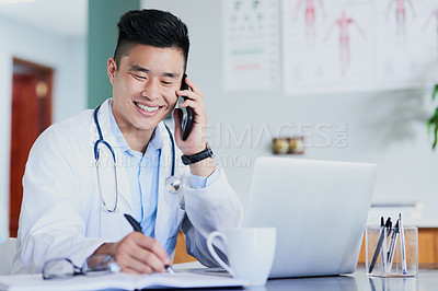Buy stock photo Cropped shot of a young male doctor making notes while working in a hospital