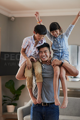 Buy stock photo Portrait of a cheerful young father holding his two children on each shoulder at home during the day