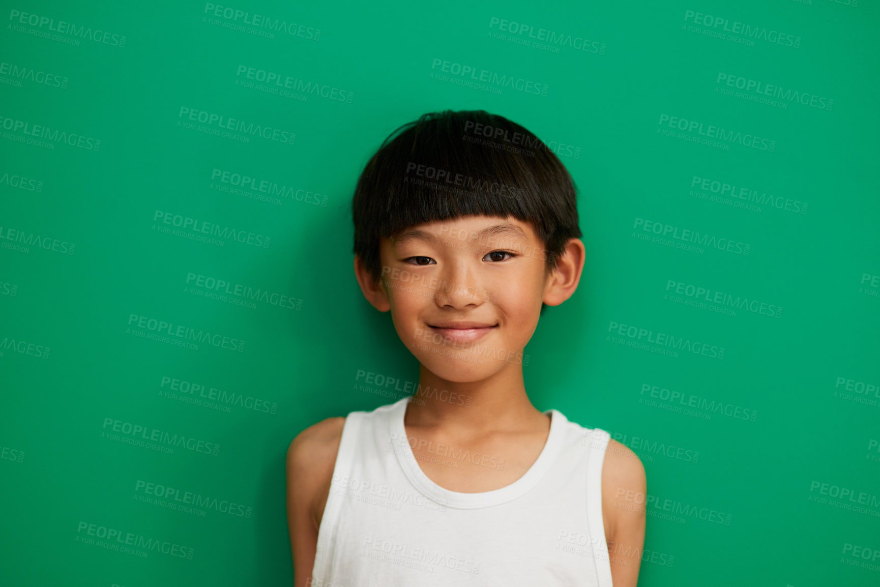 Buy stock photo Studio portrait of a cheerful little boy standing against a green background during the day