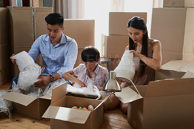 Buy stock photo Shot of a family packing boxes while moving house