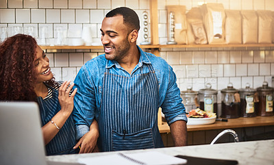 Buy stock photo Cropped shot of an affectionate young couple standing in their coffee shop