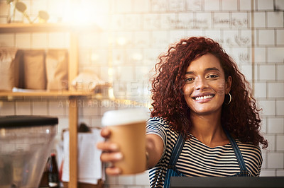 Buy stock photo Portrait of a young barista holding a cup of coffee in a cafe