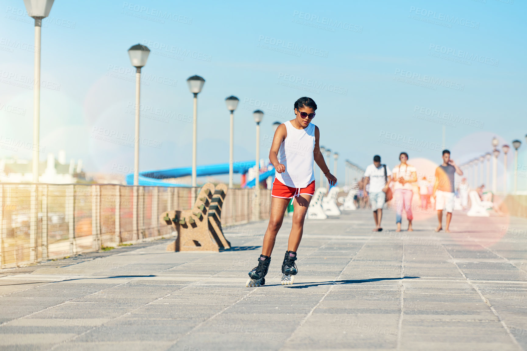 Buy stock photo Shot of an attractive young woman rollerblading on a boardwalk