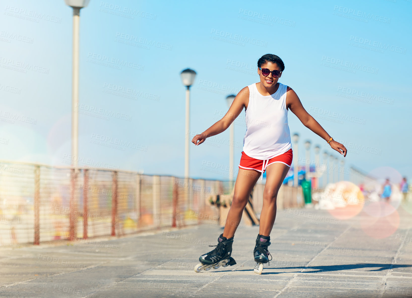 Buy stock photo Shot of an attractive young woman rollerblading on a boardwalk