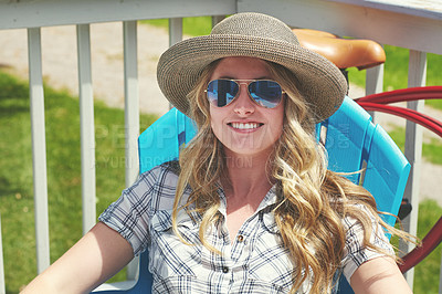 Buy stock photo Portrait of an attractive young woman relaxing on a deck chair outdoors