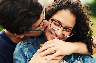 Buy stock photo Couple, teenager and kiss in park for relax, bonding and hug together on weekend with romantic gesture. Boy, girl and smile for relationship support, embrace and happy outdoor with love connection