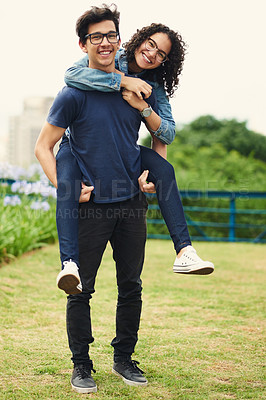 Buy stock photo Shot of a teenage girl being piggybacked by her teenage boyfriend outdoors