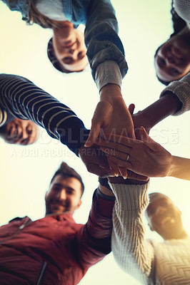 Buy stock photo Low angle shot of a group of students joining their hands in solidarity