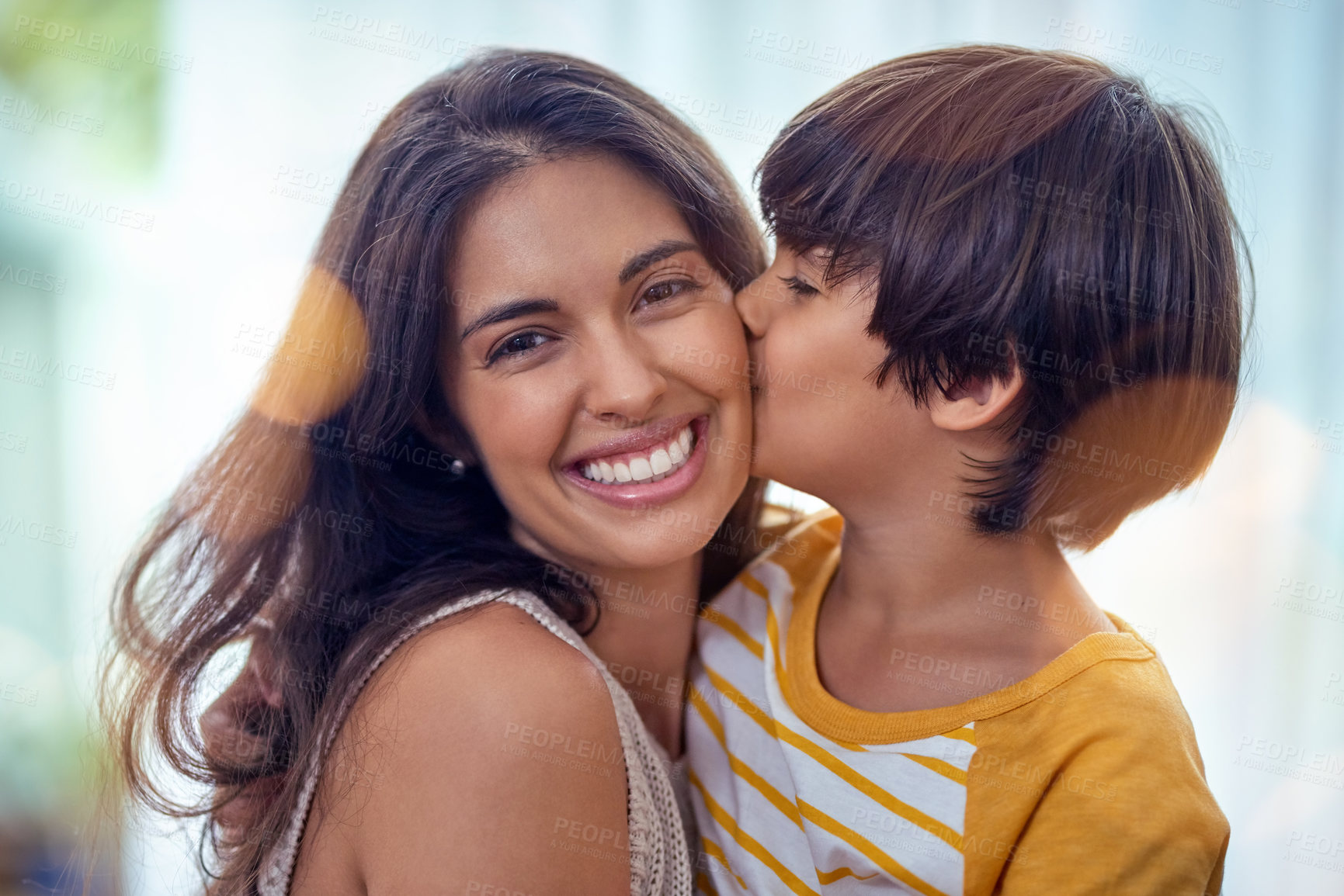 Buy stock photo Shot of an adorable little boy affectionately kissing his mother at home