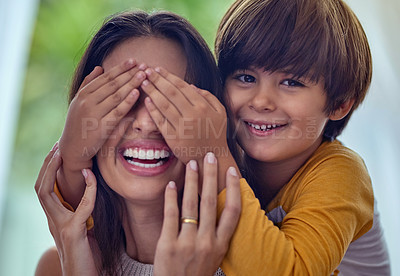 Buy stock photo Shot of an adorable little boy playfully covering his mother’s eyes at home