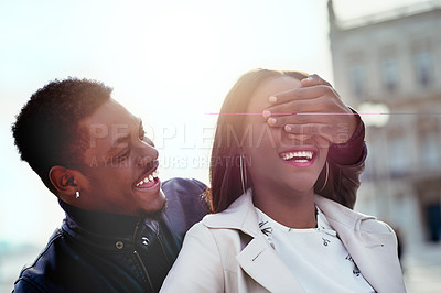 Buy stock photo Shot of a young man covering his girlfriend's eyes outdoors