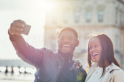 Buy stock photo Shot of an affectionate young couple taking selfies together outdoors