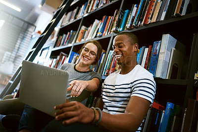 Buy stock photo Shot of a young man and woman using a laptop together in a college library