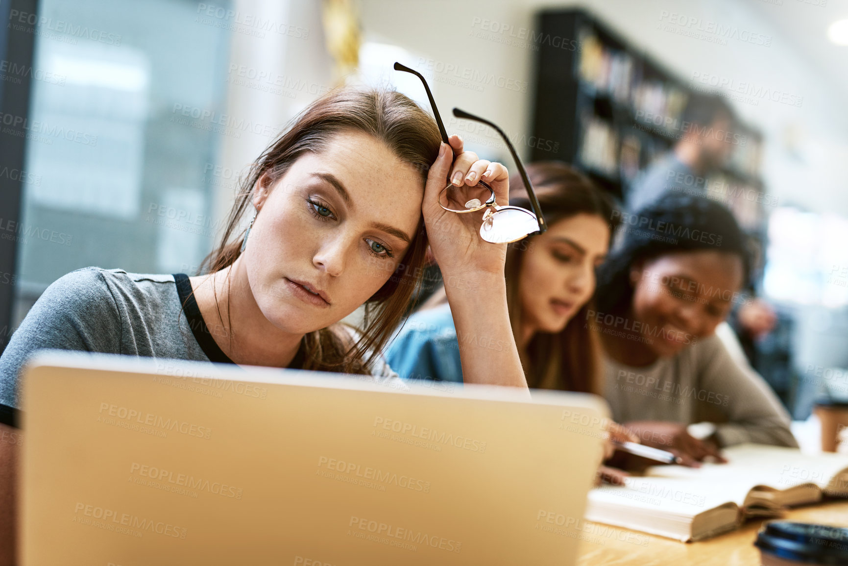 Buy stock photo Woman, stress and laptop for studying at library, college or campus with tired face, anxiety or burnout. University student, girl and computer for education, study and fatigue at school with reading