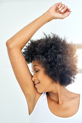 Buy stock photo Cropped shot of an attractive young woman smelling her armpits at home