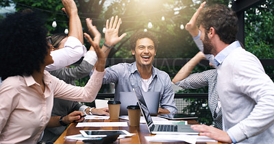 Buy stock photo Shot of a group of businesspeople high fiving during a meeting at a cafe