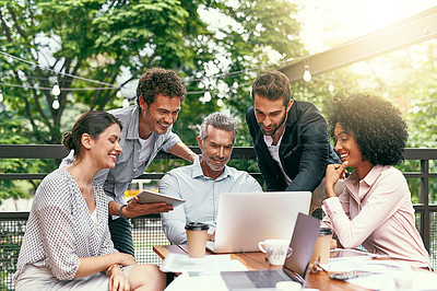 Buy stock photo Shot of a team of colleagues using a laptop and digital tablet together during a meeting outdoors