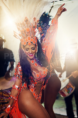 Buy stock photo Shot of a cheerful female dancer wearing a vibrant costume while dancing inside a busy nightclub