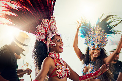 Buy stock photo Shot of two female dancers wearing vibrant costumes while dancing to music inside of a busy nightclub