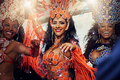 Buy stock photo Portrait of a group of female dancers wearing vibrant costumes while dancing to music inside of a busy nightclub