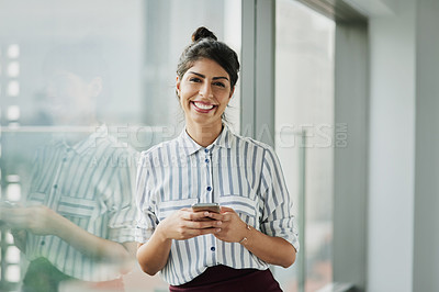 Buy stock photo Business woman, portrait and phone with happiness at office window with a smile. Young female face employee and mobile connection of a worker feeling happy on social media and technology at company
