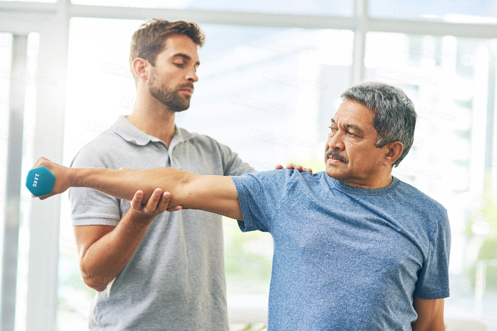 Buy stock photo Cropped shot of a young male physiotherapist assisting a senior patient in recovery