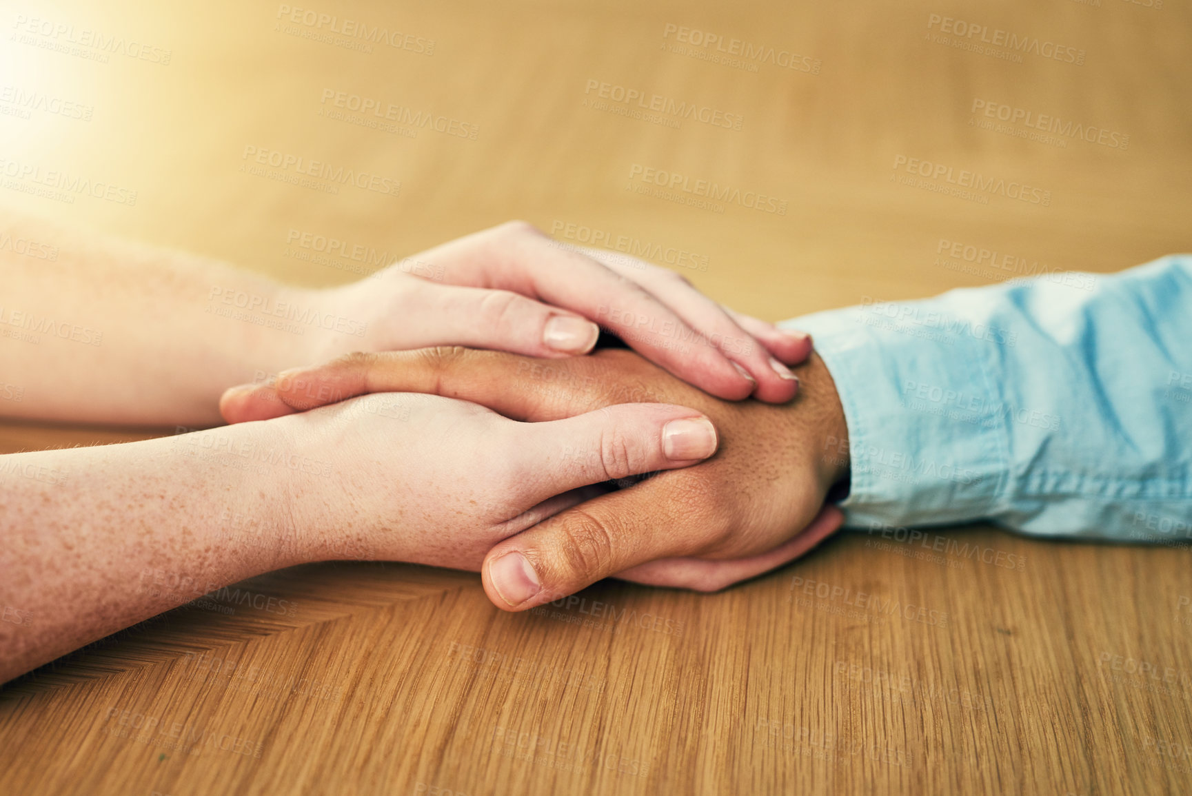 Buy stock photo Cropped shot of a man and woman holding hands in comfort on a table