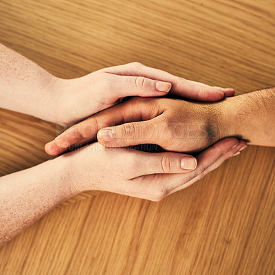 Buy stock photo Cropped shot of a man and woman holding hands in comfort on a table