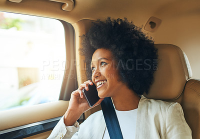 Buy stock photo Shot of a cheerful young businesswoman talking on her cellphone while being seated in the passenger seat of a car on her way to work