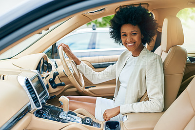 Buy stock photo Portrait of a cheerful young businesswoman seated in the driver seat of a car on her way to work during the day