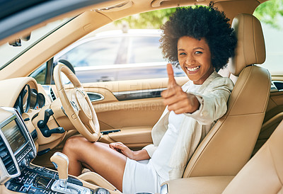 Buy stock photo Portrait of a cheerful young businesswoman driving in her car on her way to work while showing thumbs up to the camera during the day